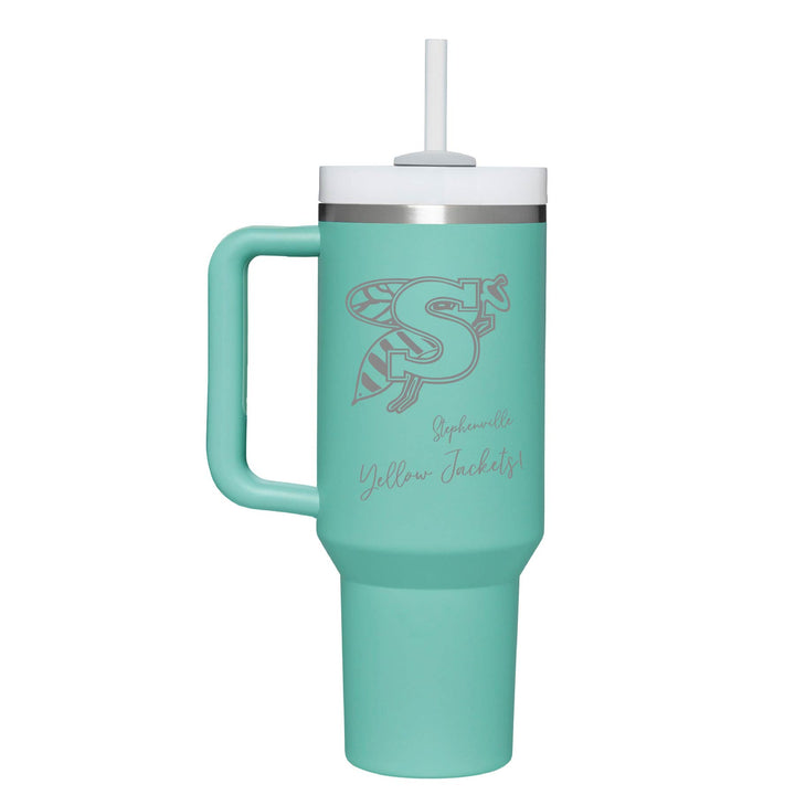 This is an insulated engraved stainless steel tumbler with a handle. The engraved image is the Stephenville Yellow Jackets logo. The cup is eucalyptus in color.