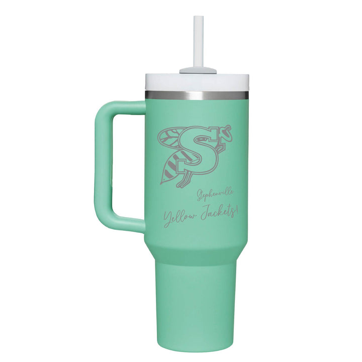 This is an insulated engraved stainless steel tumbler with a handle. The engraved image is the Stephenville Yellow Jackets logo. The cup is teal in color.